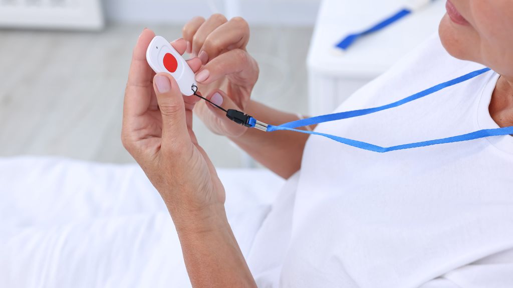 Nahaufnahme eines Hausnotruf-Handsenders mit rotem Alarmknopf